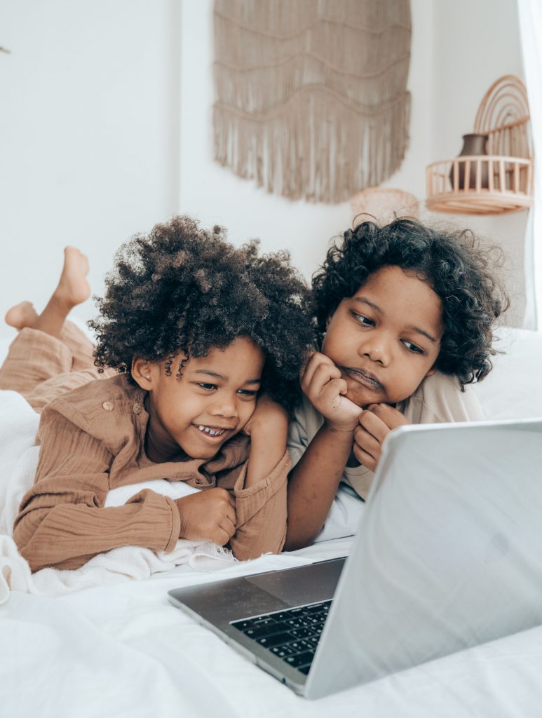 Information for children and young people. Photo of two children looking at a laptop or tablet