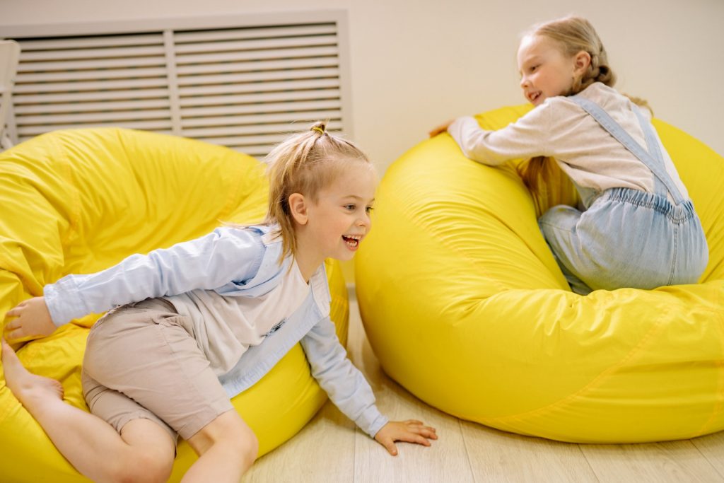 Mediation and Alternative Resolution Support. Photo of two children playing on yellow beanbags.