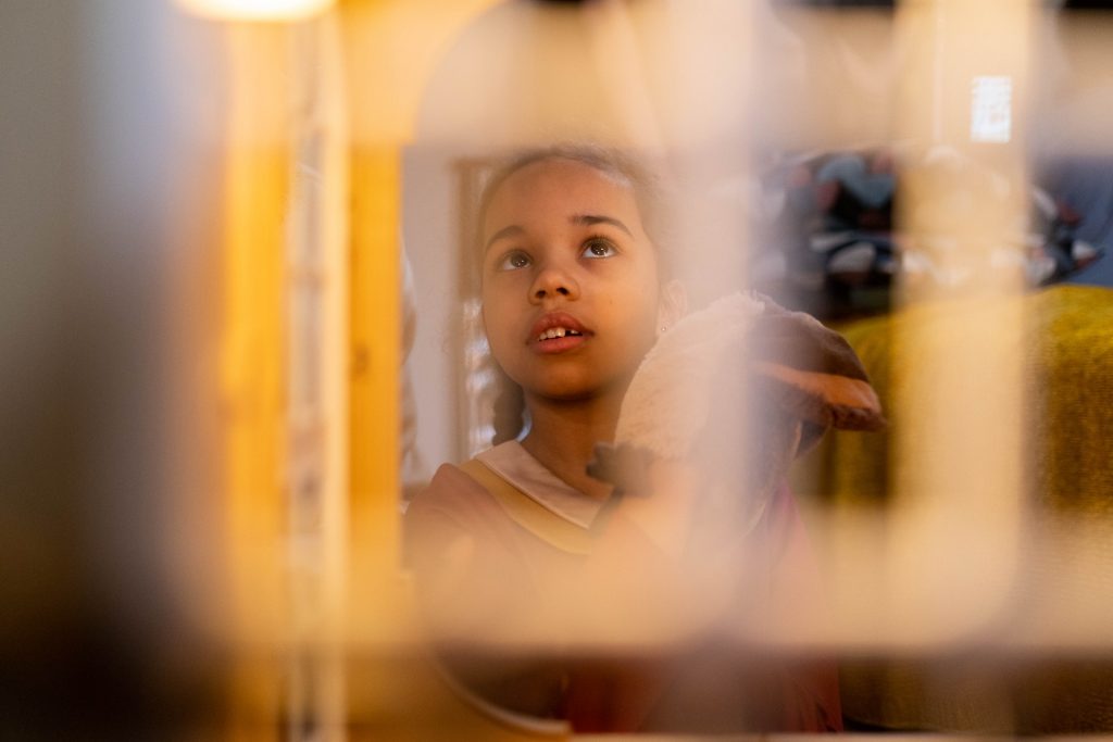Sorting finances. Photo of a child looking upwards seen through a blurred object in the foreground.